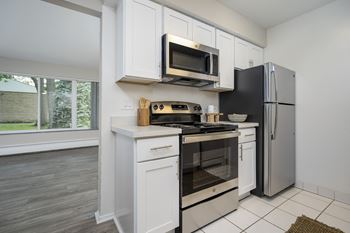 a kitchen with white cabinets and a stainless steel refrigerator